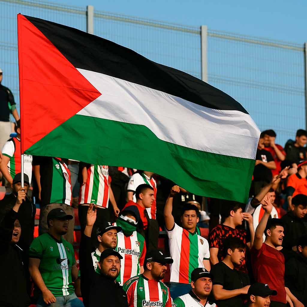Hinchas del Club Palestino alzando una bandera en La Cisterna